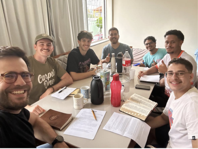 April Prayer Calendar image of seven men around a table having Bible study