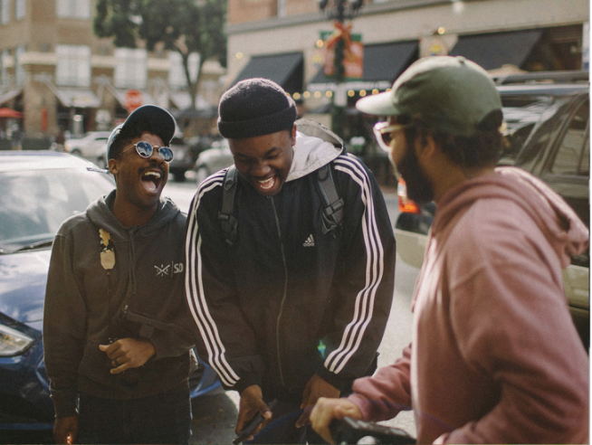 March Prayer Calendar image of three men laughing next to their car